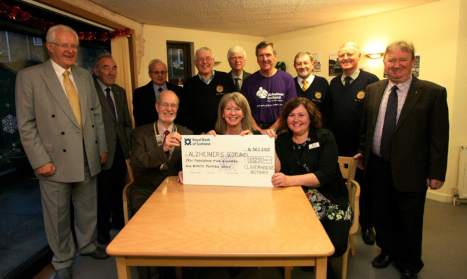 Seated, from left: president Ron Elder, Ms Robison and Gabrielle Colston, head of operations, with Rotarians.