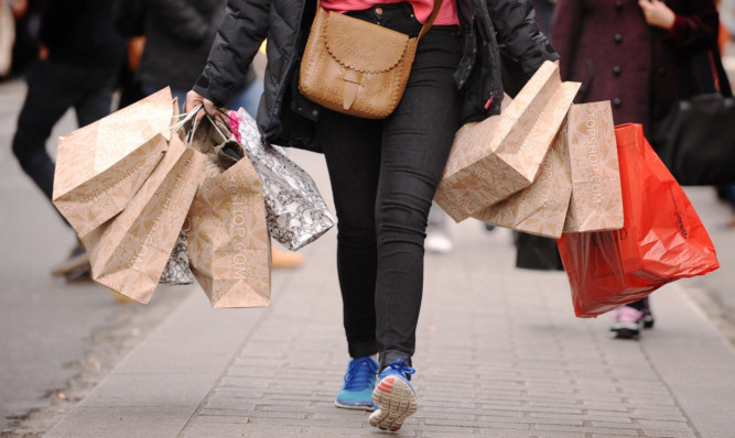 File photo dated 6/12/11 of a shopper carrying shopping bags. High street sales dropped by 2.2% last month in an "underwhelming" Christmas for many retailers, according to a report. ... High street sales ... 06-01-2014 ... London ... UK ... Photo credit should read: Dominic Lipinski/PA Wire. Unique Reference No. 18604411 ... Issue date: Monday January 6, 2014. Figures from accountancy firm BDO showed the sales surge hoped for by many shops failed to materialise in the crucial trading period, with like-for-like sales - excluding online trade - dropping by as much as 6.7% in the week to December 22. See PA story ECONOMY Retail. Photo credit should read: Dominic Lipinski/PA Wire