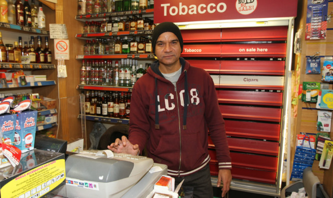 Shop owner Nadeem Rao counts the cost of the terrifying robbery after dark on Tuesday evening.