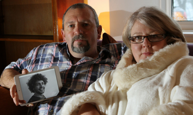 Gregs parents, Peter and Tina Boswell, with a picture of their son.