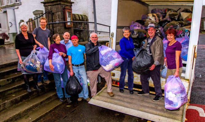 Residents fill one of the vans with some much-needed clothing.