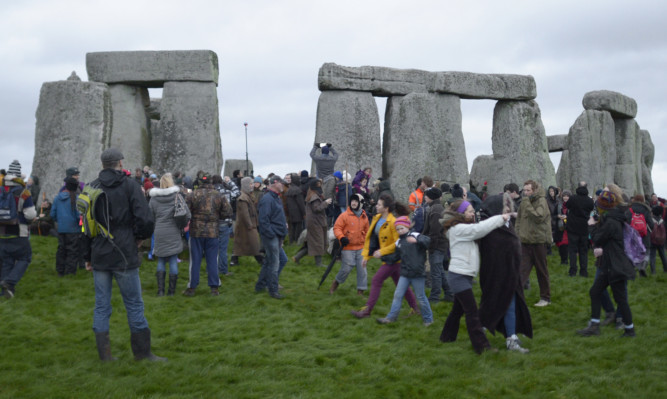 People gather at Stonehenge in Wiltshire on the Winter Solstice to witness the sunrise on the shortest day of the year.