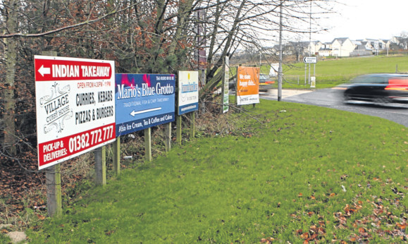 The advertising boards at the entrance to Panmurefield Village on the A92.