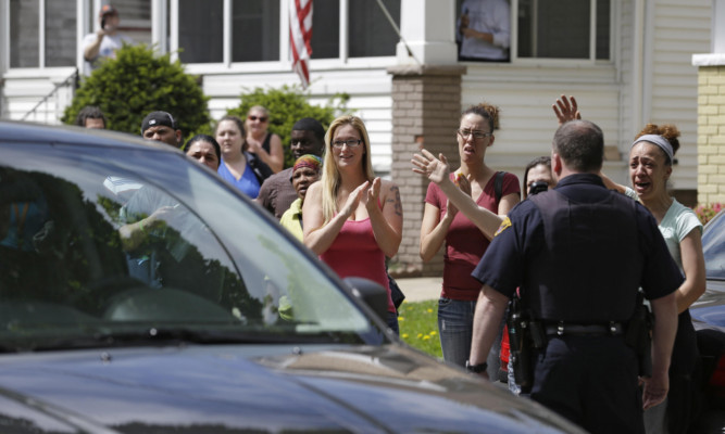 Neighbors and friends of Amanda Berry clap as she arrives at her sister's home.