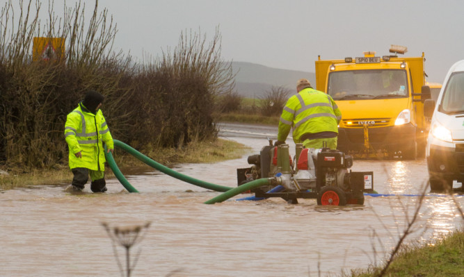 Fife Council workers pumping water away on the A91.
