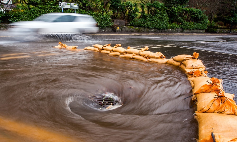 Steve MacDougall, Courier, A923 Dunkeld. Bad flooding on roads around Dunkeld. Pictured, sandbags trying to encourage the water down the drain.