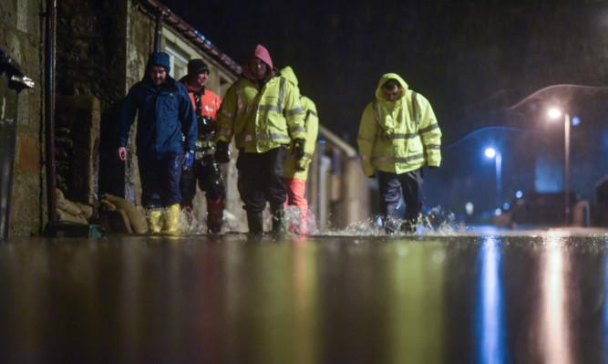 Men search homes in the Port Elphinstone area of Inverurie after the River Don burst its banks.