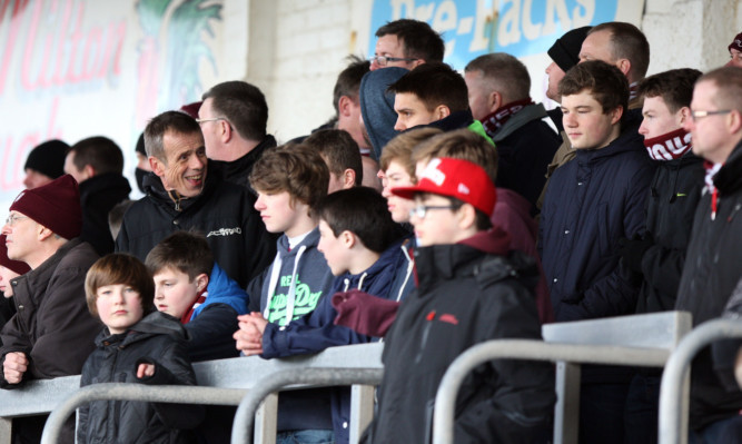 Kris Miller, Courier, 22/02/14. Picture today at Gayfield, Arbroath where filming was taking place for a series on footballs foreign outposts. Pic shows Tom Watts (former Eastenders actor) in the stands with fans at Arbroath Football Club.