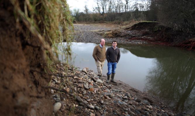 Bob and Rob Strachan in a stubble field at Lochlands Farm that was filled with stones and rubble when the River Ericht burst through banks designed to protect fields.