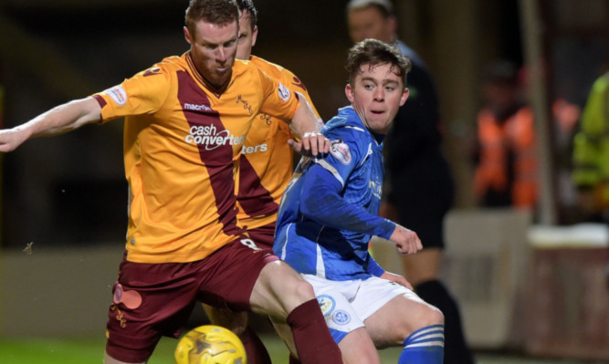 Craig Thomson challenges for the ball with Motherwell's Stephen Pearson.