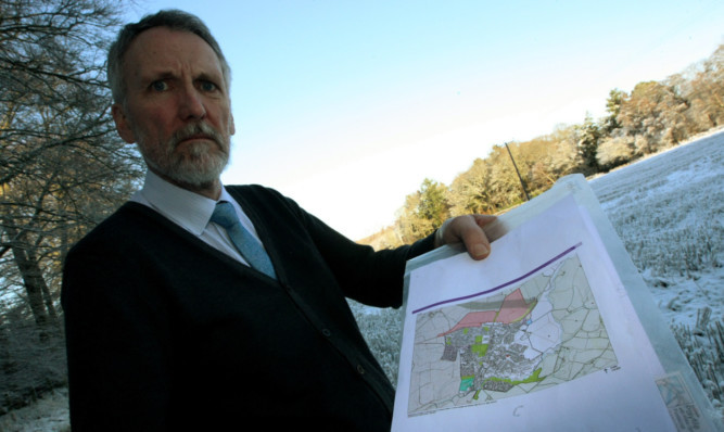 Councillor Lewis Simpson with a map showing the proposed housing development for Scone.