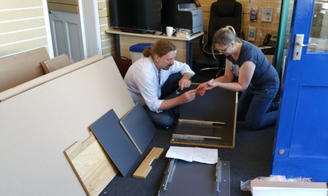 Chris Law and Roisin Smith, a case worker at his constituency office, build the new furniture.