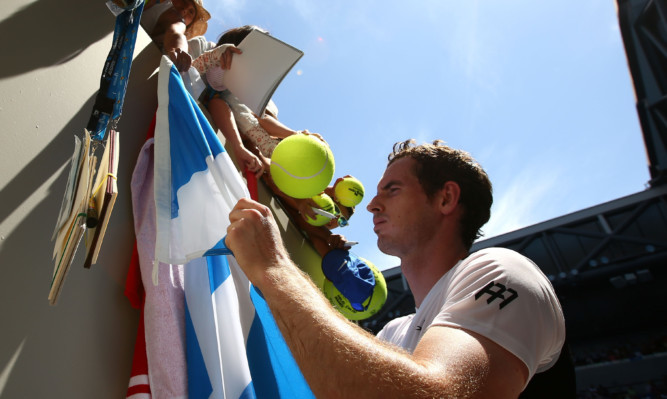 Andy Murray signs autographs after winning his first round match against Alexander Zverev.