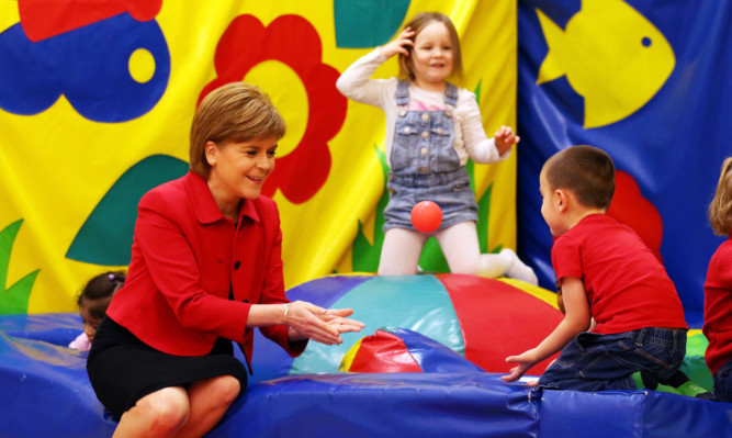 First Minister Nicola Sturgeon plays with children in a ball pit during a  visit childcare charity North Edinburgh Childcare.