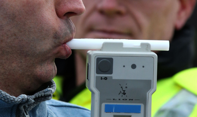 PICTURE POSED BY MODEL
Road Traffic constable John Parry from Police Scotland demonstrates breathalyser equipment at a drink-drive limit change awareness event at Lockerbie Police Station, Scotland, as the reduced drink-driving limit comes in to force at the end of this week.  ... Reduced drink drive limit ... 03-12-2014 ... Lockerbie ... UK ... Photo credit should read: Andrew Milligan/PA Wire. Unique Reference No. 21635129 ... Picture date: Wednesday December 3, 2014. The Scottish Parliament last month unanimously approved measures to reduce the legal limit from 80mg to 50mg per 100ml of blood with the change coming into force from Friday. See PA story SCOTLAND Alcohol. Photo credit should read: Andrew Milligan/PA Wire