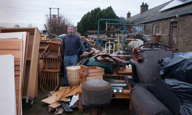 Bill McIntosh with wrecked possessions outside his home at Castleton Cottages, Eassie.