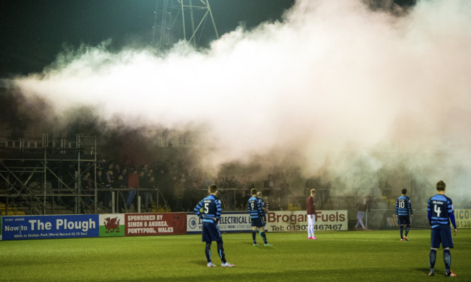 The match was called off after visiting fans set off flares and smoke bombs at Station Park.