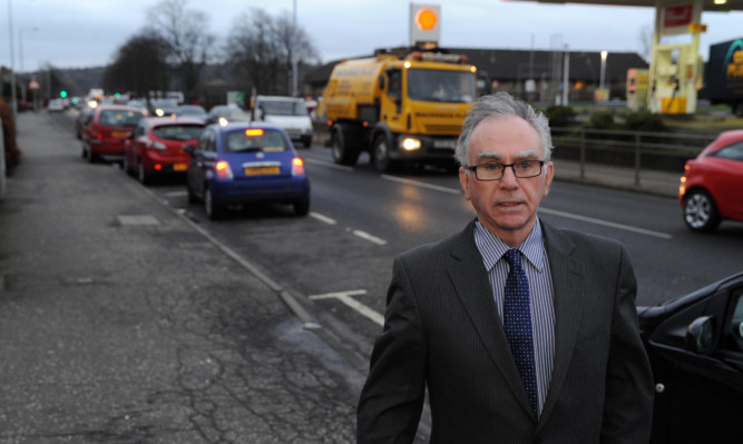Cllr Mike Shirkie next to the traffic at Admiralty Road,.
