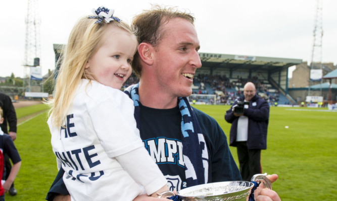 Gary Irvine with one of his daughters after Dundee won the Championship title.