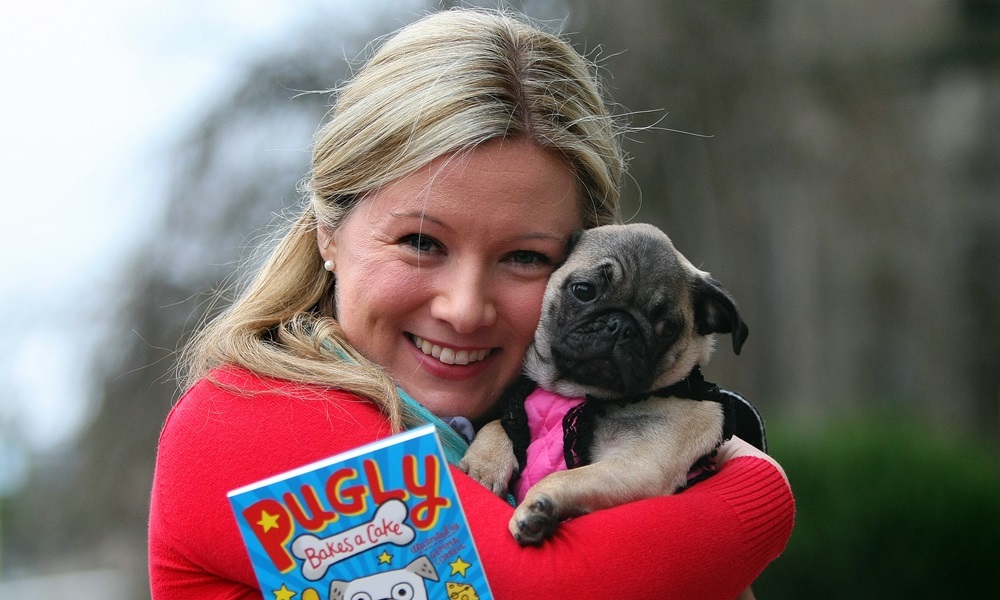 Kris Miller, Courier, 31/01/16. Picture today outside Brewdog Dundee where Pamela Stewart launched her latest book 'Pugly Bakes a Cake' and invited 17 pugs who she befriended locally to the launch. Pic shows Pamela with the book and one of the VIP guests.