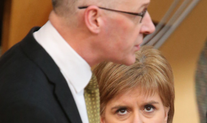 Nicola Sturgeon watches John Swinney in action at the Scottish Parliament.