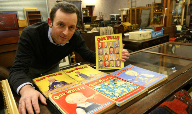 Auctioneer Steven Dewar with one of the Oor Wullie annuals up for sale.