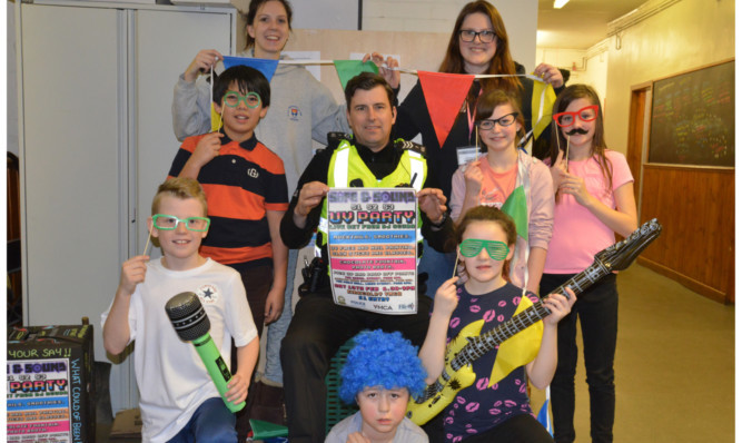 Back, from left: Youth workers Tessa Simm and Kerry Willison with Sgt Jimmy Adamson and youngsters to promote the party at Kirkcaldy YMCA.