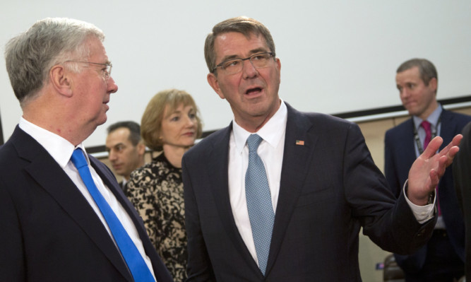 U.S. Secretary of Defense Ash Carter, right, speaks with British Secretary of State for Defence Michael Fallon.