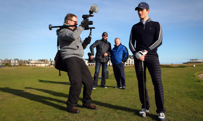 David Valentine, in the blue jacket, watches on as filming takes place on the 18th hole of the Championship Course.