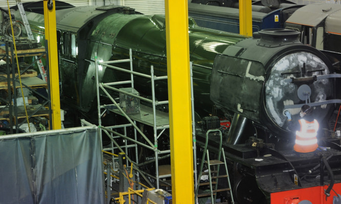 Alterations are made to the Flying Scotsman, freshly painted in green livery ahead of its official return to steam next week, in a workshop at the National Railway Museum in York.