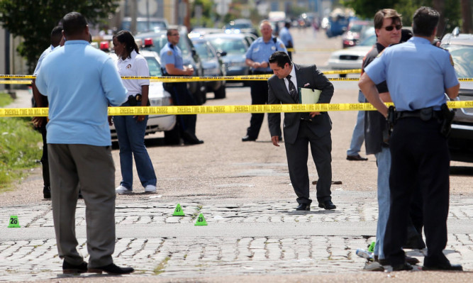 New Orleans police officers investigate the scene at the intersection of Frenchmen and N. Villere Streets in New Orleans.