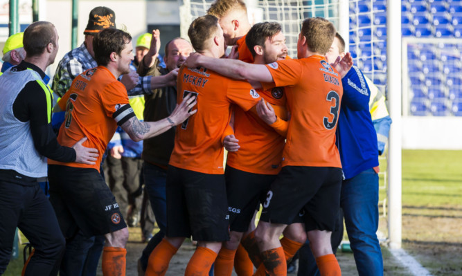 The jubilant United players celebrate Ryan Dow's goal.