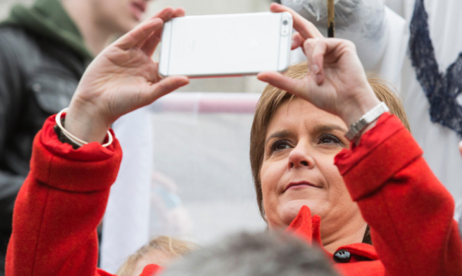 Nicola Sturgeon snaps a picture during the anti-Trident rally in London