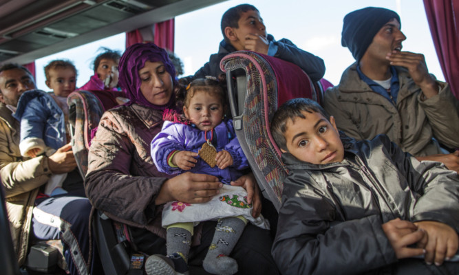 Families wait on a bus as they travel north from Athens to the Greek-Macedonia border in Polikastro, Greece.