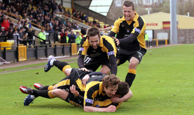 Liam Gormley is mobbed after scoring the winner for the Fifers.
