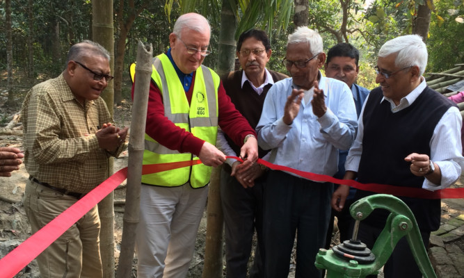 Hugh Begg, from the Rotary Club of Monifieth and District, inaugurates a well at Duttapukur village in West Bengal, watched by Calcutta Rotarians.