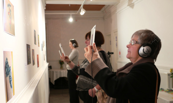 Gowrie Care chairwoman Janet Lynch experiences the art display at Roseangle.