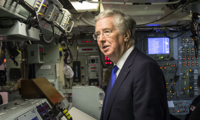 Defence Secretary Michael Fallon in the control room onboard Vanguard-class submarine HMS Vigilant.