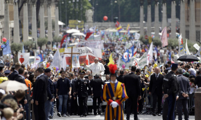 Pope Francis greets the faithful along Via della Conciliazione at the end of the canonisation mass.