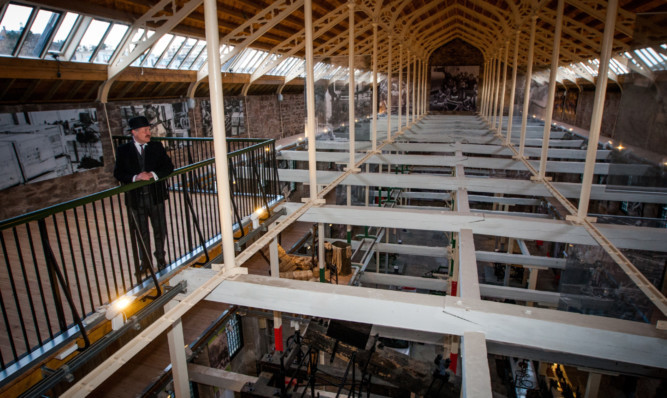 volunteer guide Richard Irvine, dressed as a works manager, takes a look around the new gallery.