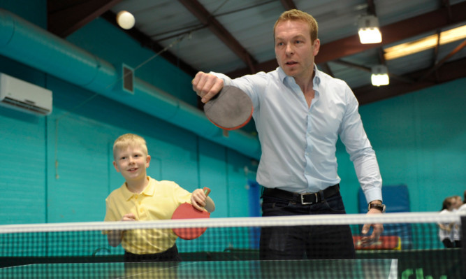 Olympic champion Sir Chris Hoy tries his hand at rackets sports, with Liam Sanders, 9,  at Drumchapel Sports Centre in Glasgow.