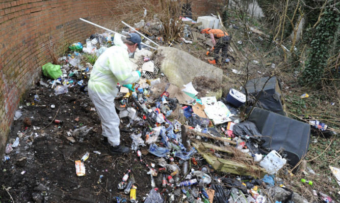 A Fife Council worker begins the process of cleaning up the area.