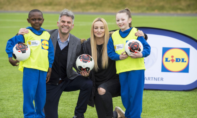Former Scotland players Darren Jackson and Suzanne Grant join Lasine Diaby and Lexi Henderson from St Anne's Primary School to celebrate Lidl UK's partnership with the Scottish FA.
