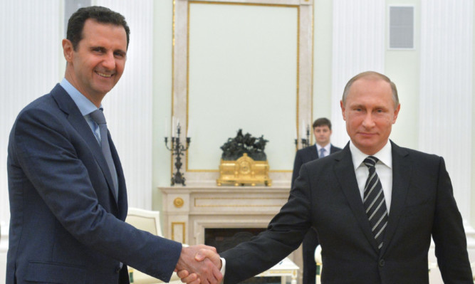 Presidents Assad and Putin shake hands  but just what are Putins intentions?