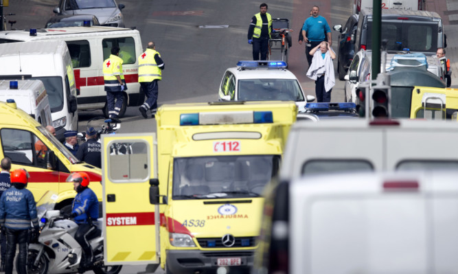 Emergency services evacuate a victim wrapped in a blanket after a explosion in a main metro station in Brussels.