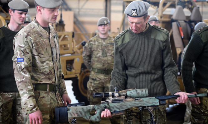 His Royal Highness The Duke of Kent  inspects a snipers rifle with Lance Corporal 
Cameron Hendry.