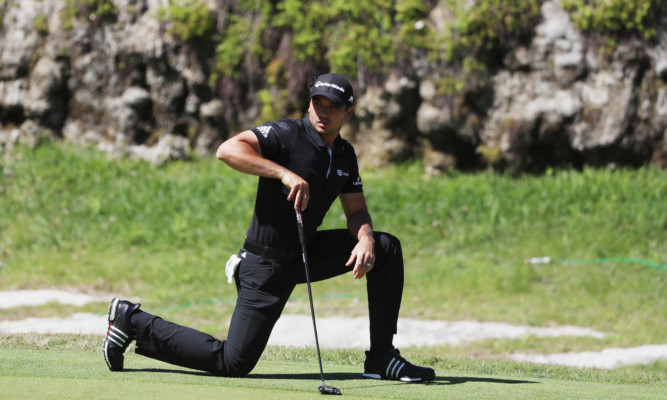 Jason Day stretches on the third green.