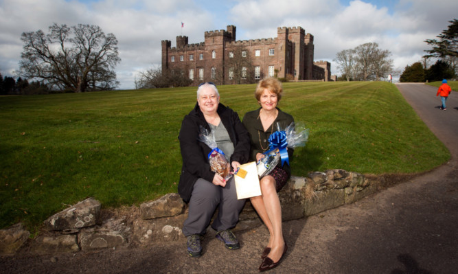 Lady Mansfield, right, presents a bottle of Champagne and gifts to Scone Palaces first visitor of the 50th season, Rosie Henderson.