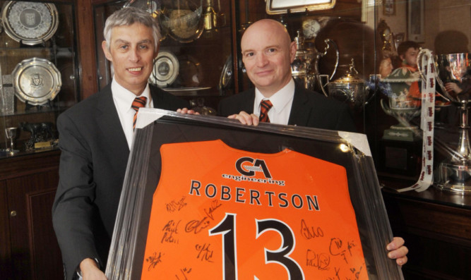 Derek Robertson (left) receiving a signed United strip from chairman Stephen Thompson.