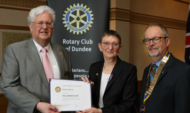 Mr Burns receives his Paul Harris Fellowship for work with amputees like Naduni, below, from Dr Janet Lowe, chairman of District 1010, and president David Laing.